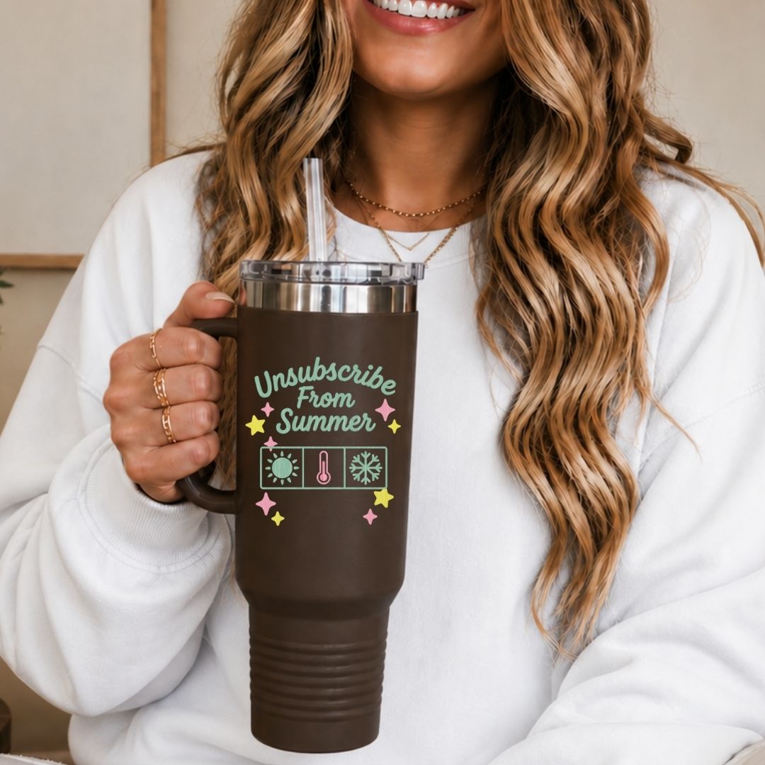 Person holding a brown mug with 'Unsubscribe From Summer' text and graphics.