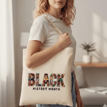 Person holding a tote bag with 'Black History Month' design in a home setting