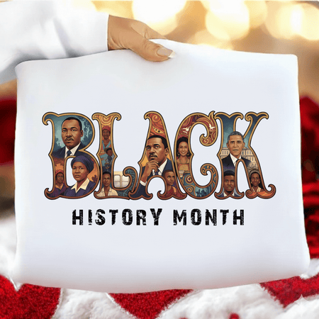 White pillow with 'Black History Month' design featuring portraits and text, held by a person against a blurred background.
