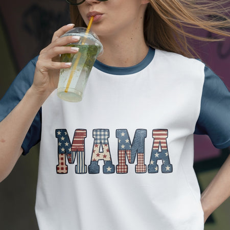 Person wearing a 'MAMA' t-shirt with American flag design, holding a drink.