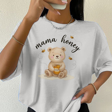 White t-shirt with a bear graphic and 'mama honey' text worn by a person.