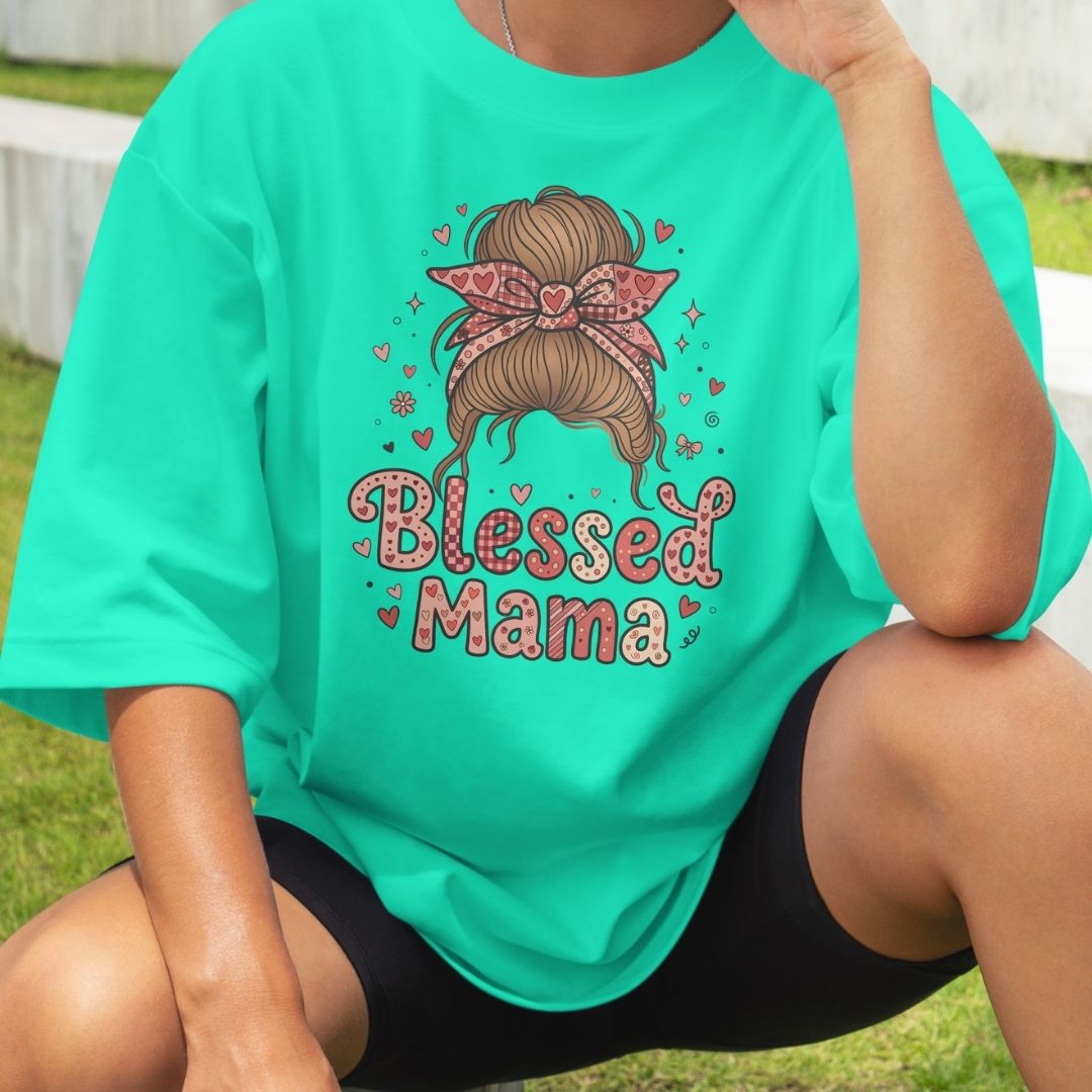Person wearing a teal t-shirt with 'Blessed Mama' design outdoors.