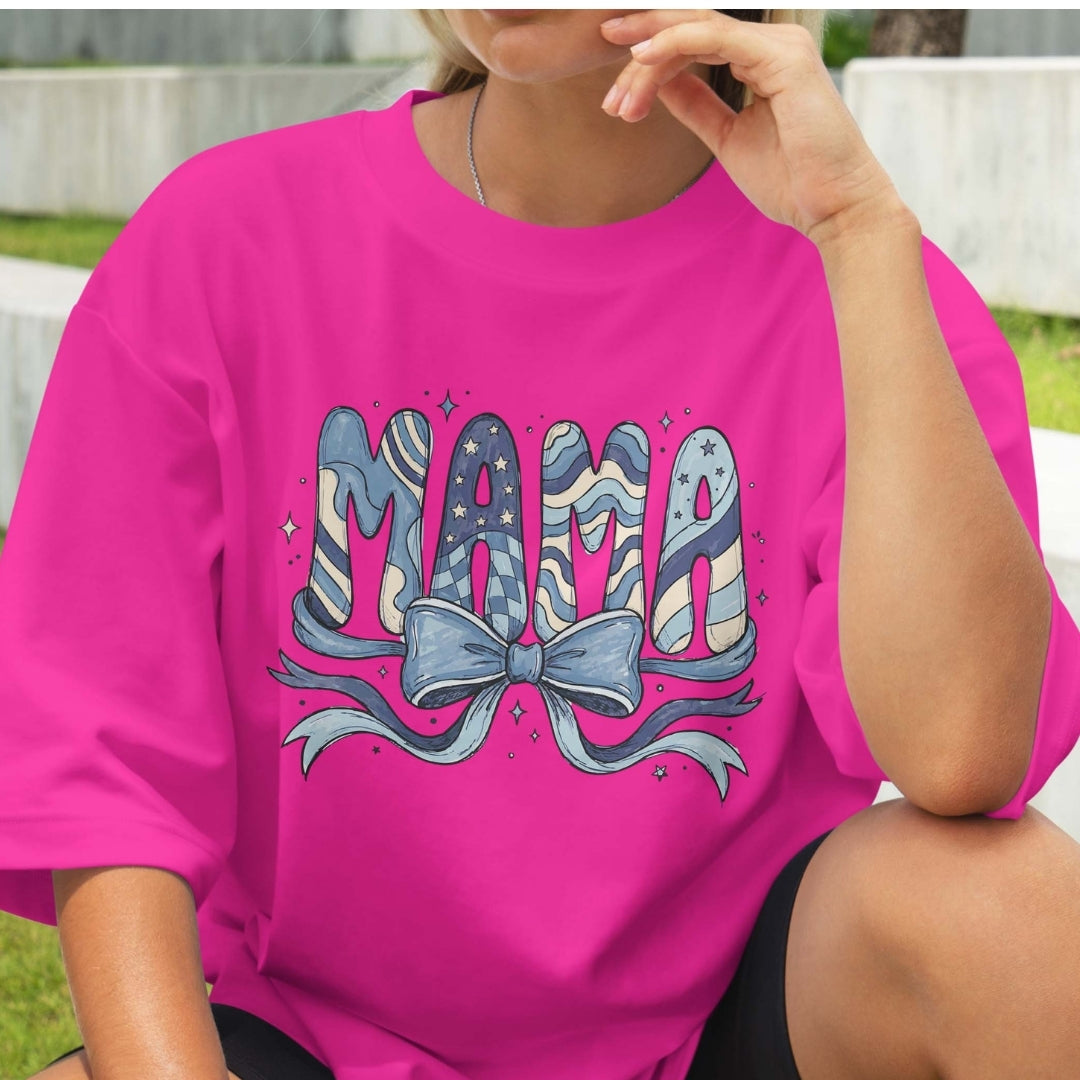 Person wearing a pink t-shirt with 'MAMA' design outdoors