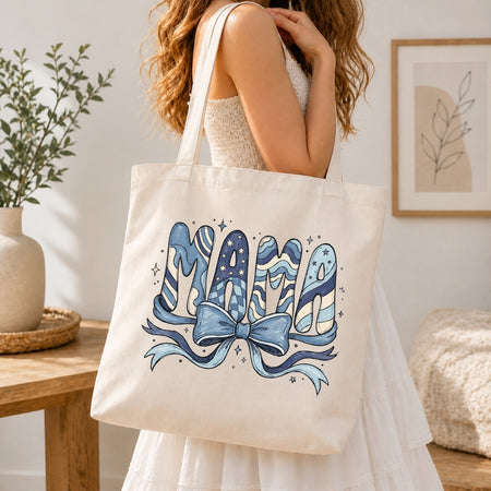 Person holding a tote bag with 'Mama' design in a home setting