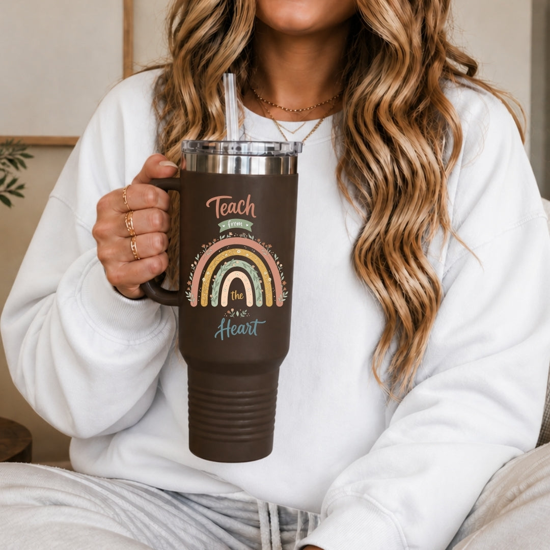 Person holding a brown mug with a rainbow design and text.