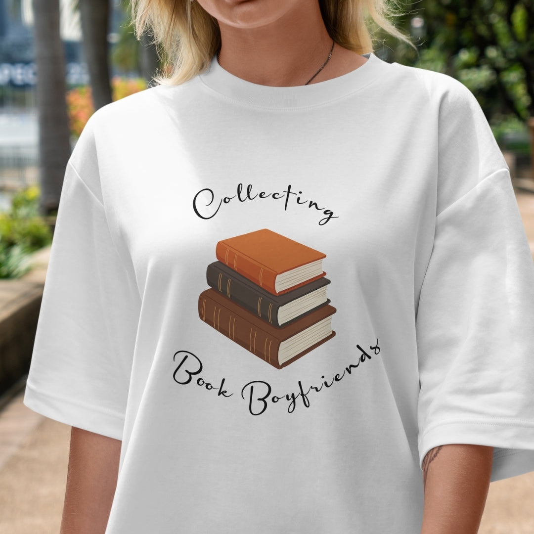 White t-shirt with book-themed design and text worn by a person outdoors.