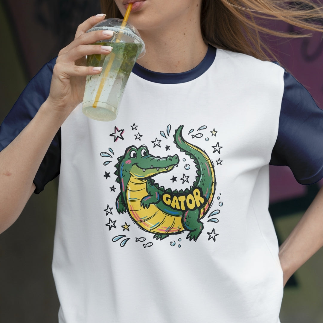 Person wearing a white t-shirt with a gator graphic and 'GATOR' text, holding a drink.