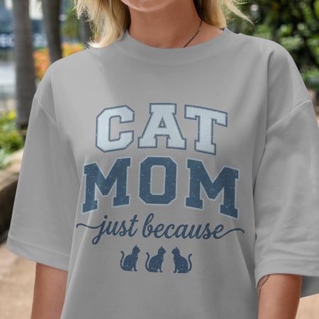 Person wearing a gray t-shirt with 'CAT MOM just because' text and cat illustrations.