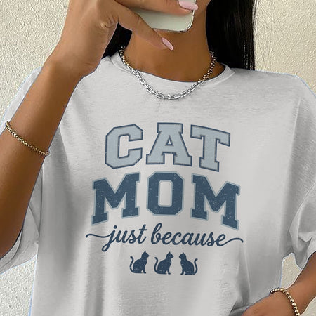 Person wearing a white t-shirt with 'CAT MOM just because' text design.