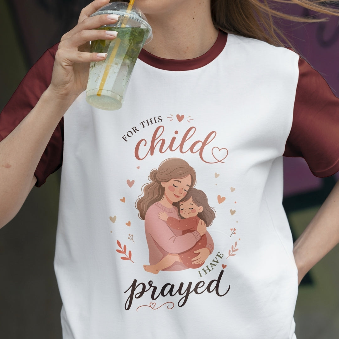 Person wearing a t-shirt with a graphic and text, holding a drink.