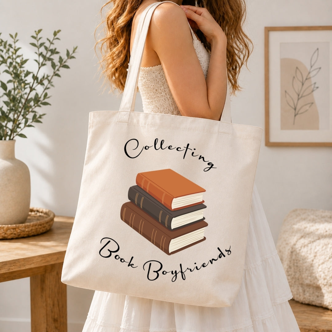 Person holding a tote bag with 'Collecting Book Boyfriends' text and book illustration.