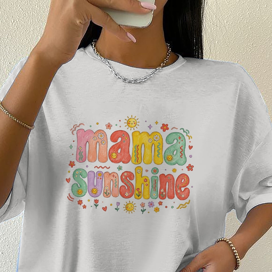 Close-up of a woman in a white crewneck t-shirt featuring a colorful retro "Mama