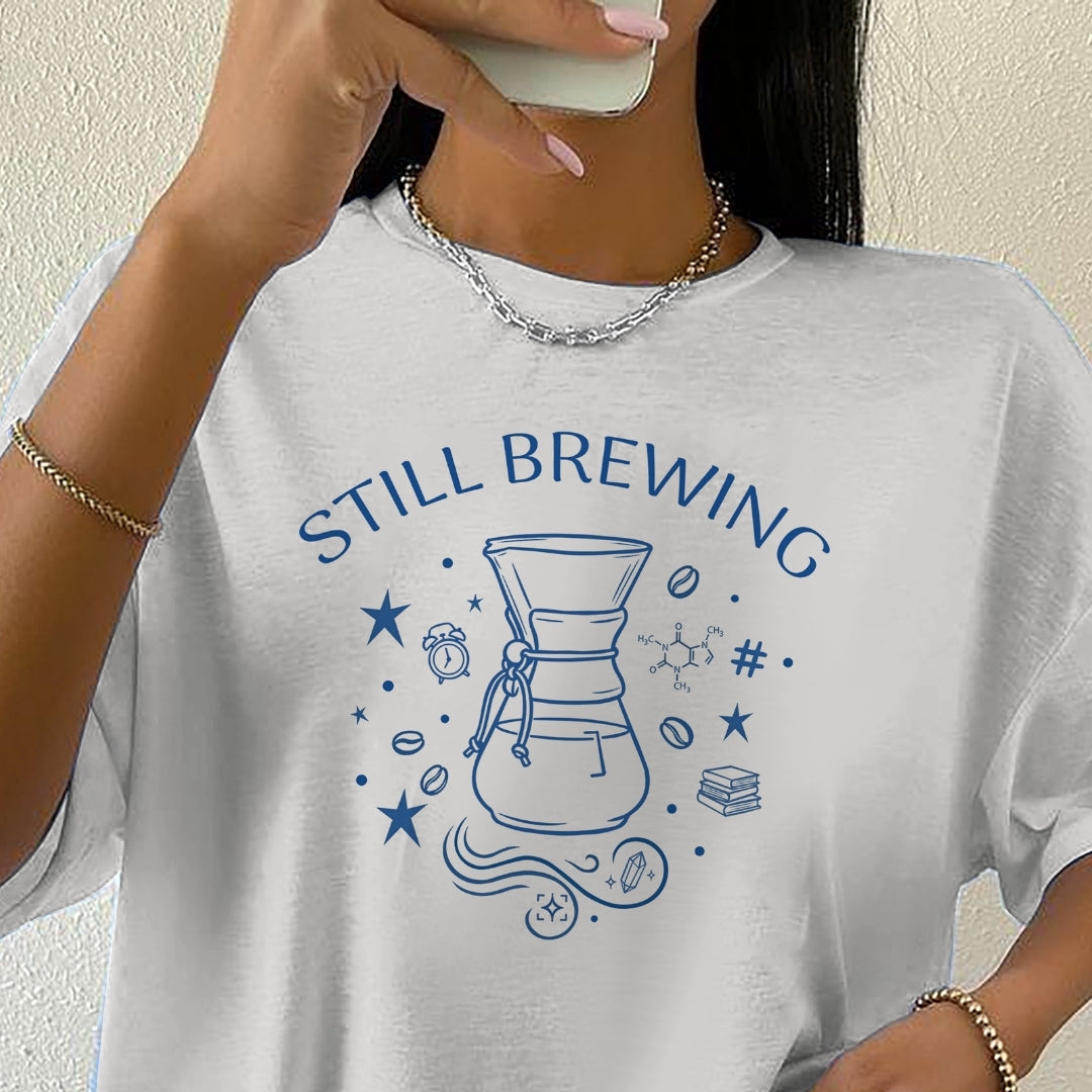 Person wearing a white t-shirt with 'STILL BREWING' design and holding a phone.