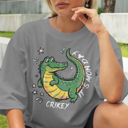 Person wearing a gray t-shirt with a cartoon crocodile design and text.