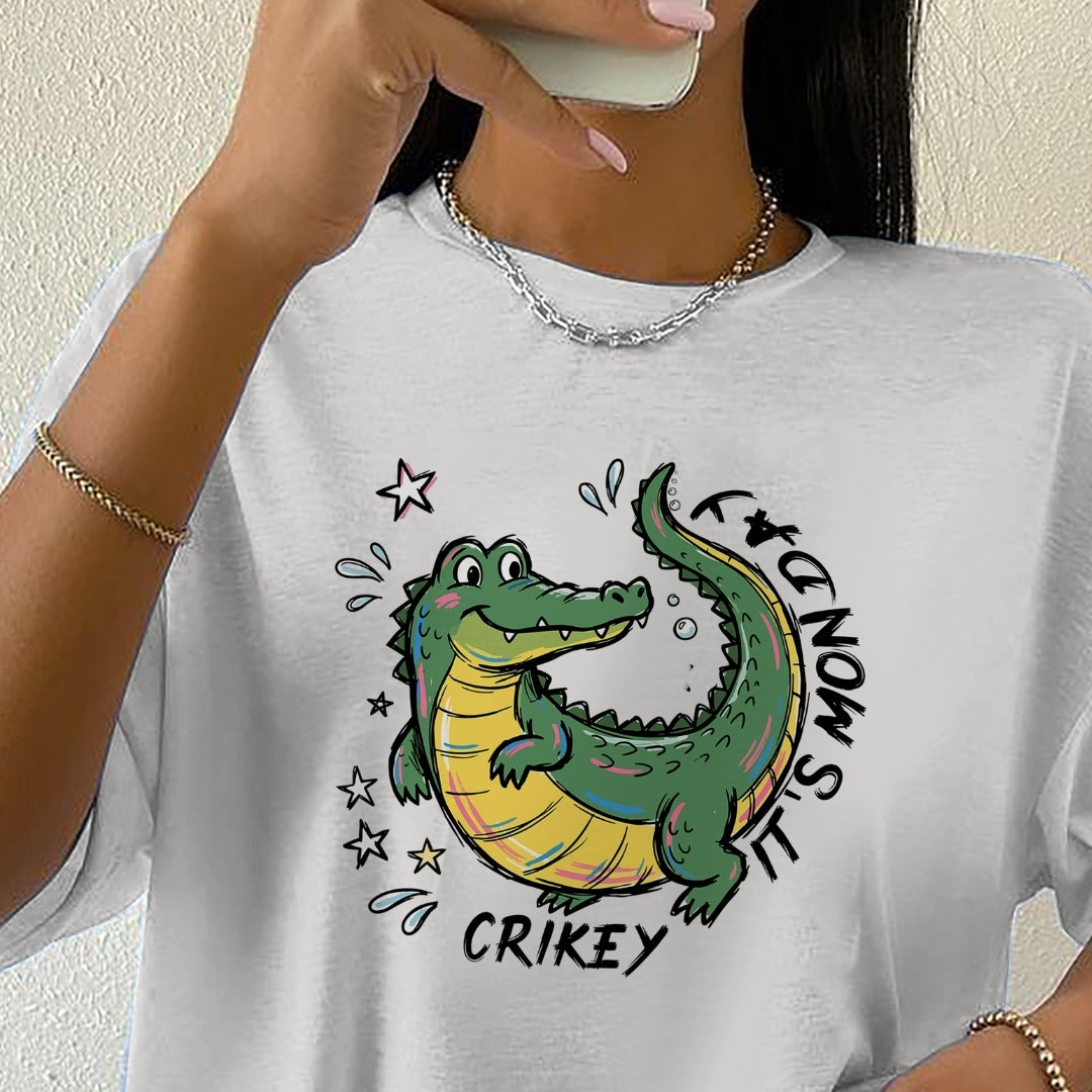 Person wearing a white t-shirt with a cartoon crocodile graphic and text.