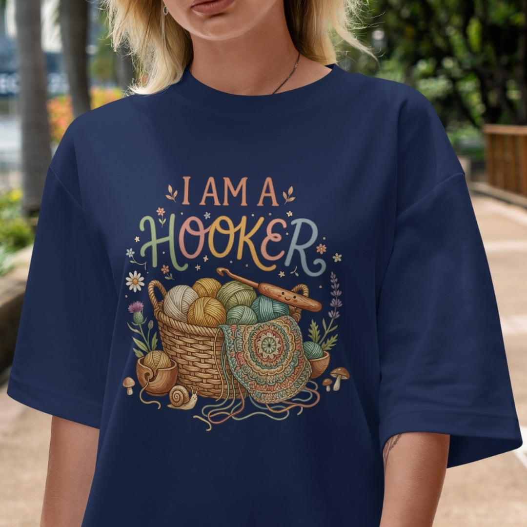 Person wearing a navy blue t-shirt with 'I AM A HOOKER' design outdoors.