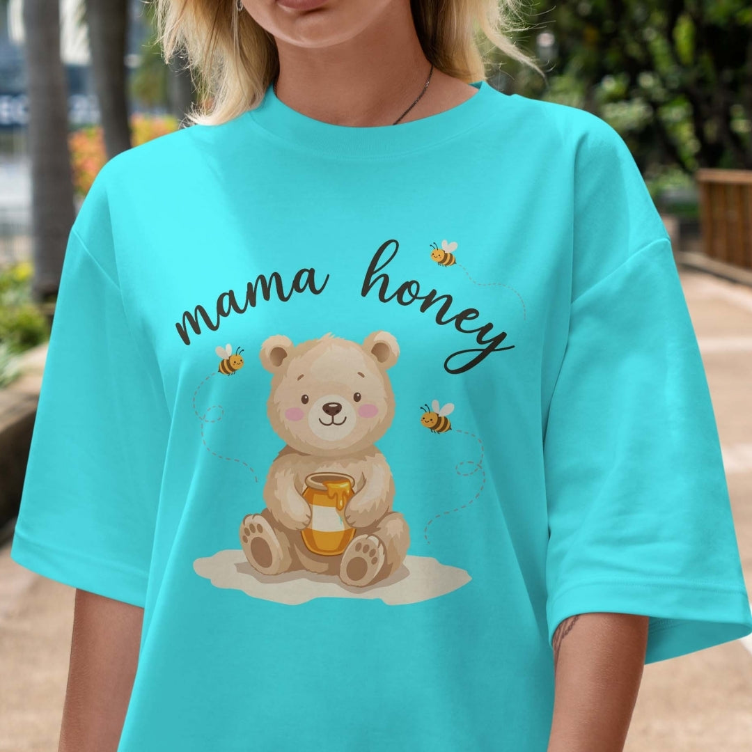 Person wearing a turquoise t-shirt with a bear holding honey and 'mama honey' text.