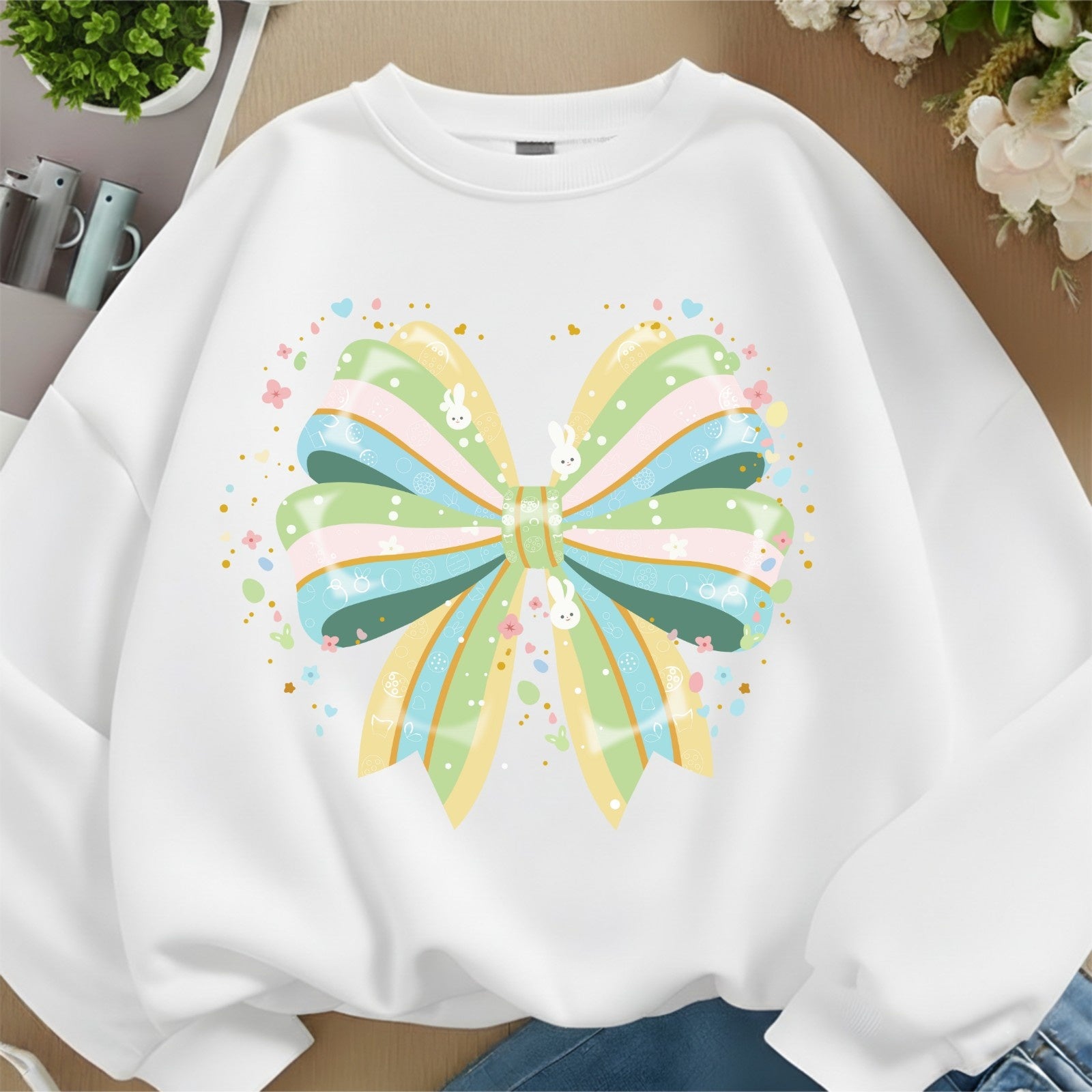 White sweatshirt with a colorful butterfly design on a neutral background
