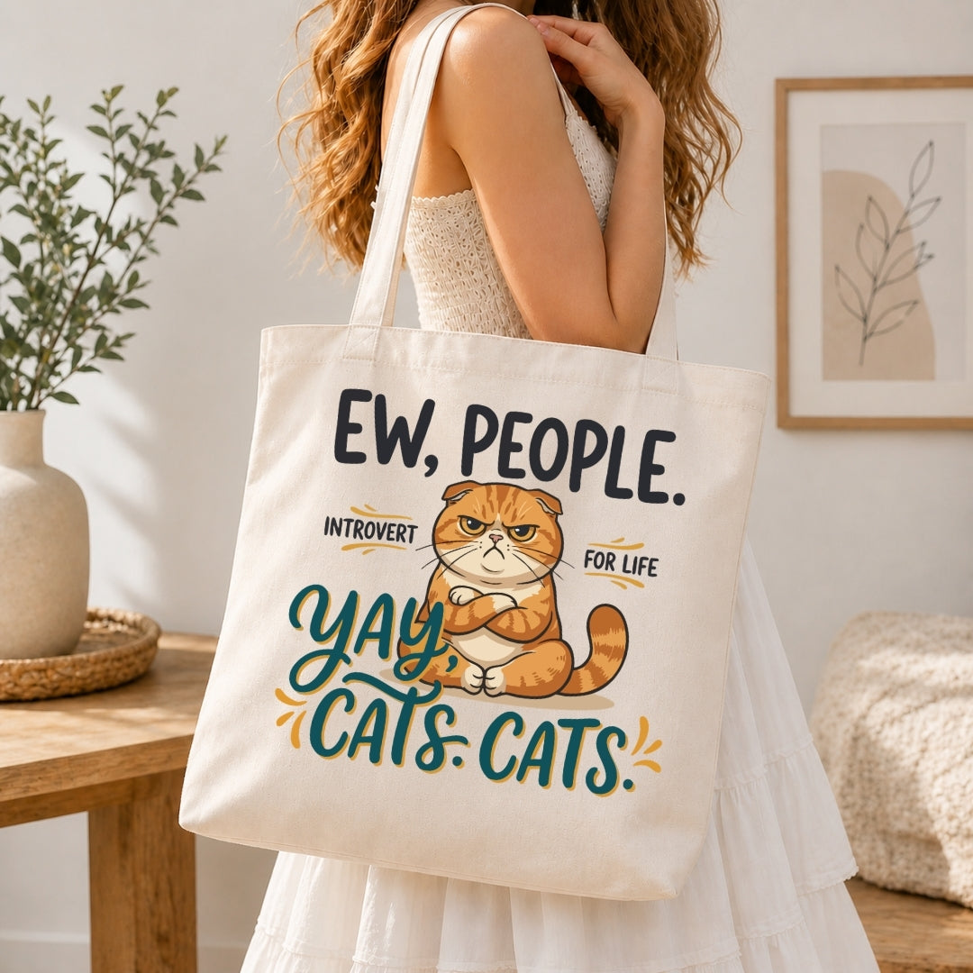 Person holding a tote bag with a cat graphic and text in a home setting