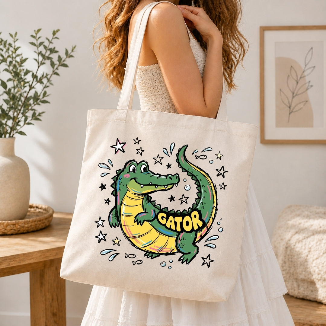 Person holding a tote bag with a cartoon alligator design and 'GATOR' text.