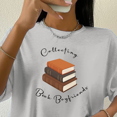 Gray t-shirt with book-themed design and text, worn by a person.