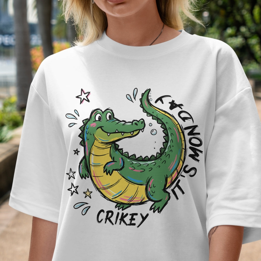Person wearing a white t-shirt with a cartoon alligator design and text.