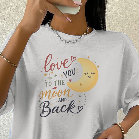 Person wearing a white t-shirt with a moon and text design.