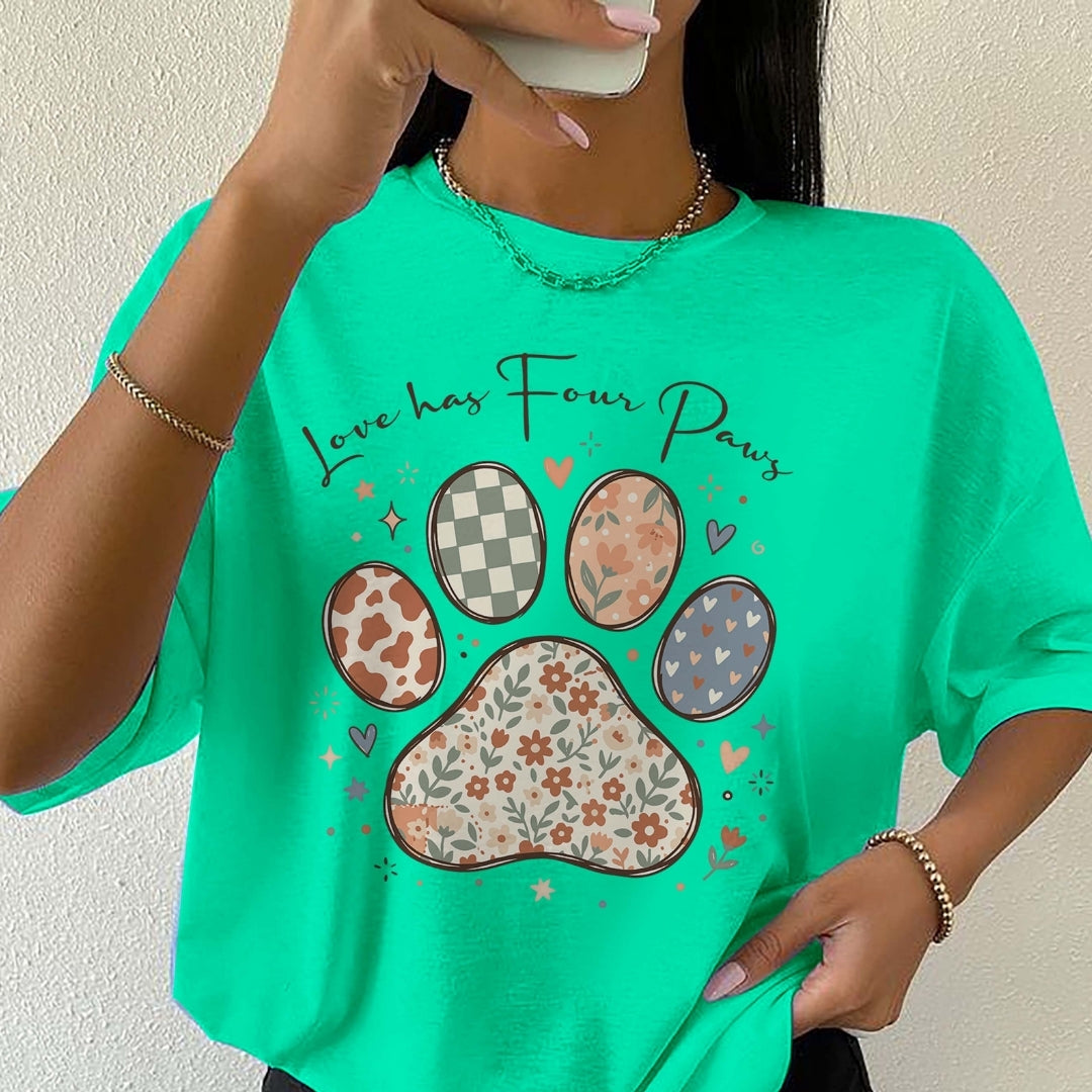 Person wearing a green t-shirt with paw print design and text 'Love has Four Paws'.