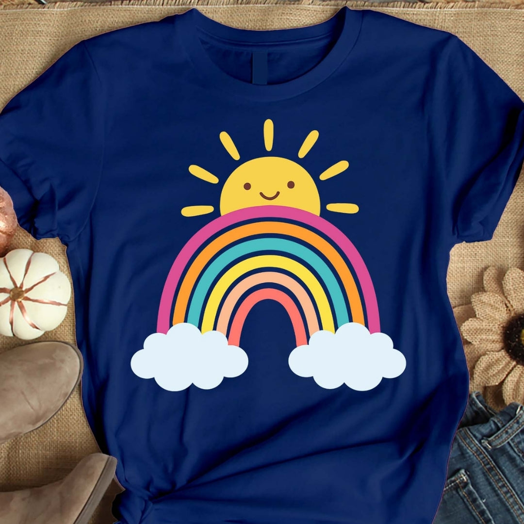 Blue t-shirt with a rainbow and sun design on a textured surface
