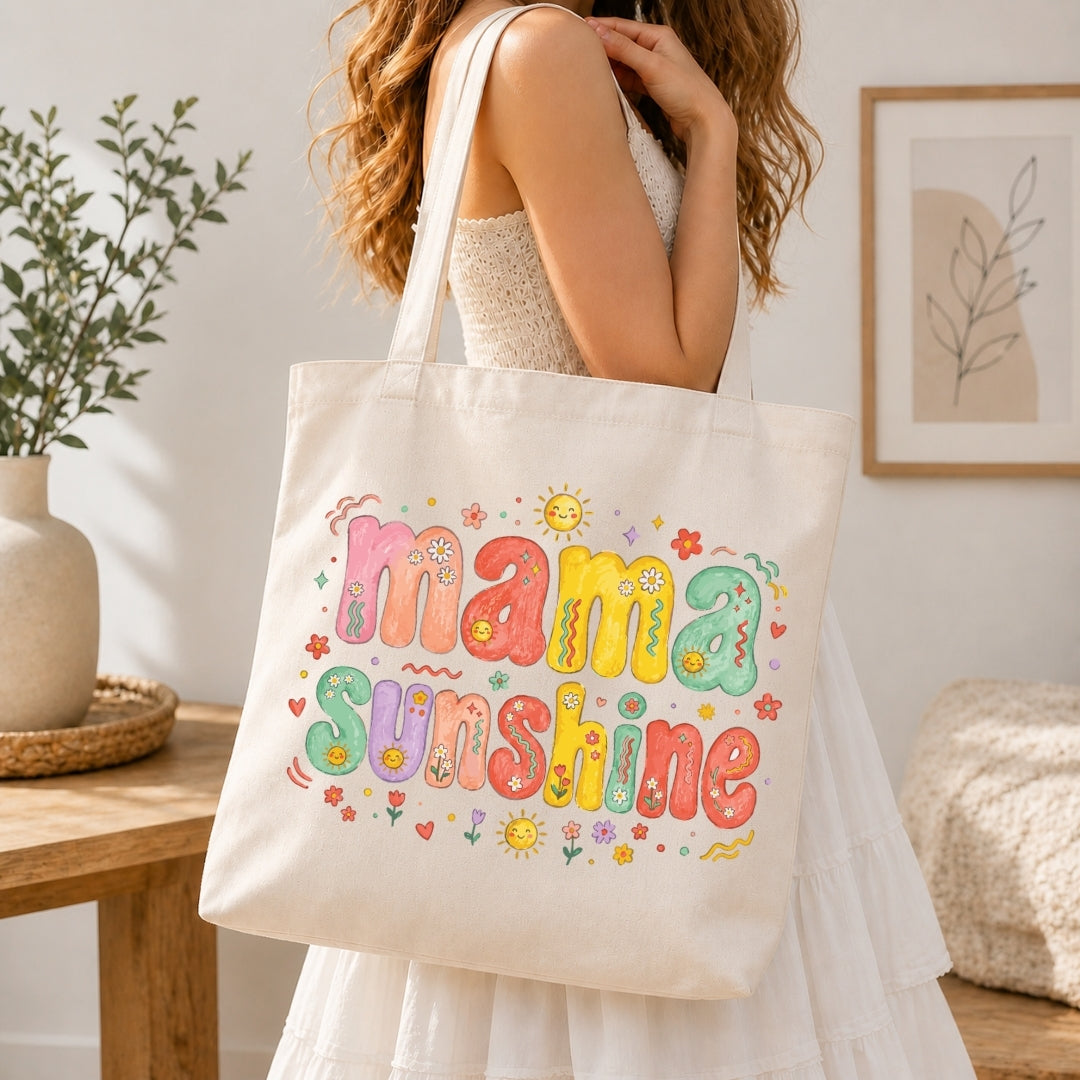 Woman in a white dress carrying a cream-colored canvas tote bag printed with a large, vibrant 70s style "Mama Sunshine" floral illustration over her shoulder.