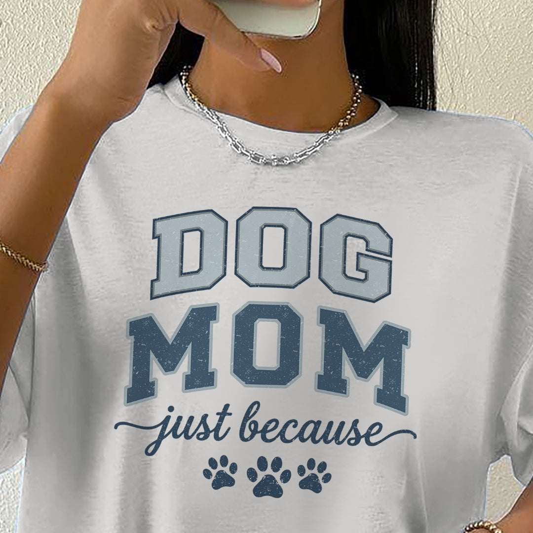 White t-shirt with 'DOG MOM just because' text and paw prints worn by a person.