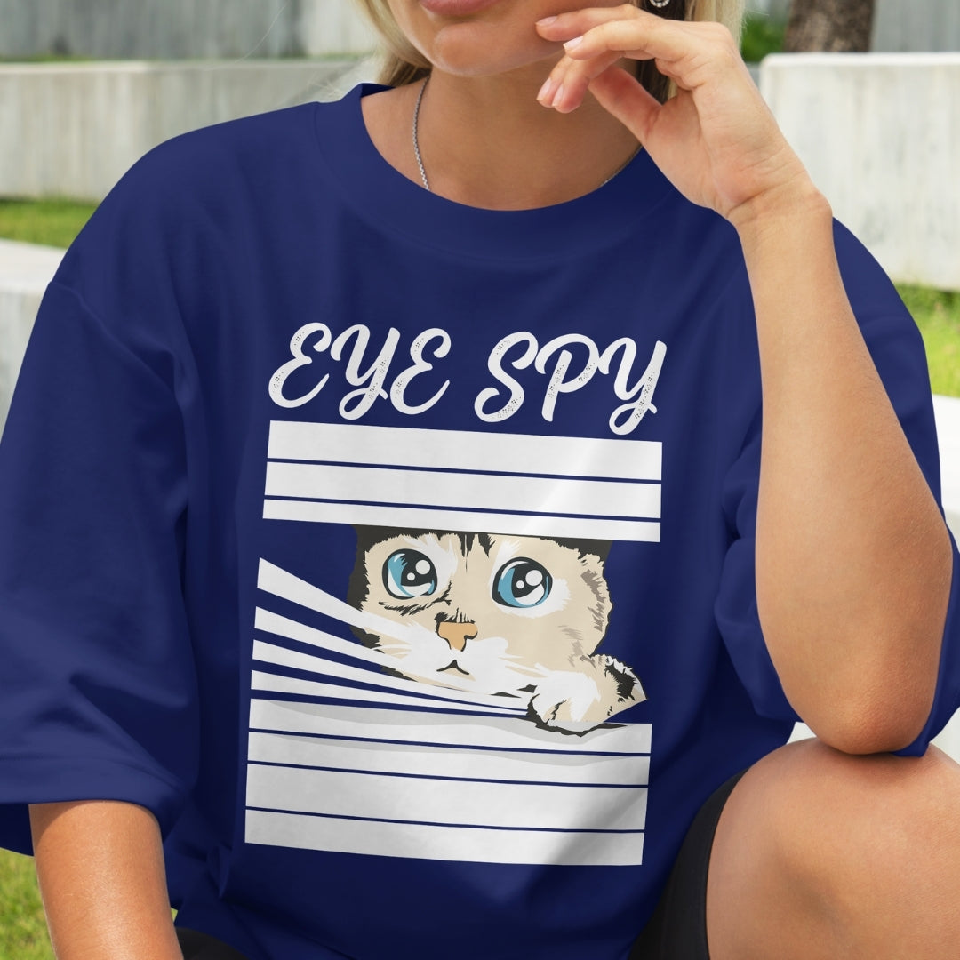 Person wearing a blue t-shirt with a cat graphic and 'EYE SPY' text.