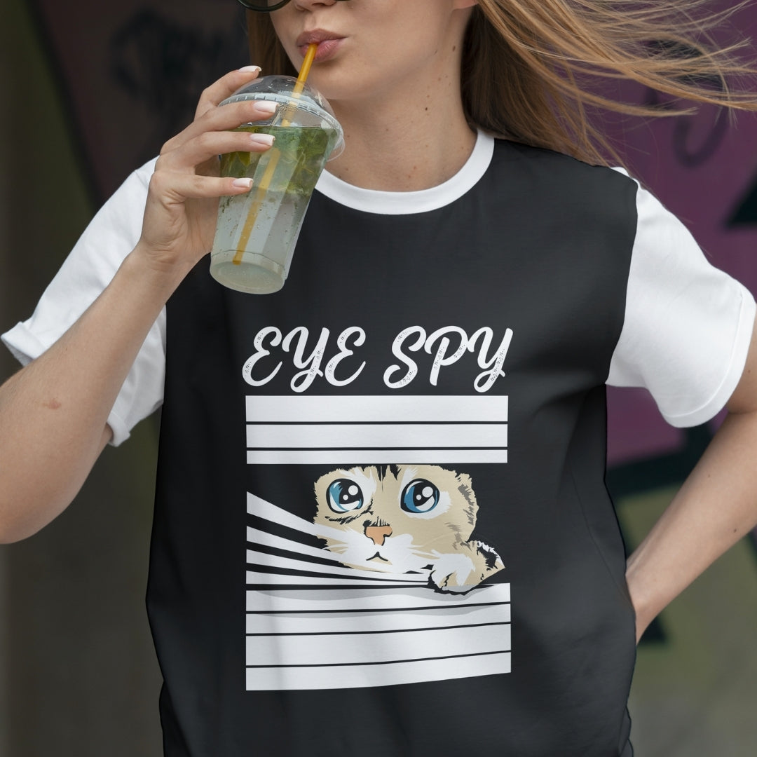 Person wearing a black t-shirt with a cat graphic and 'Eye Spy' text, holding a drink.