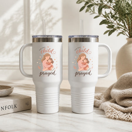 Two white tumblers with a design and text on a neutral background