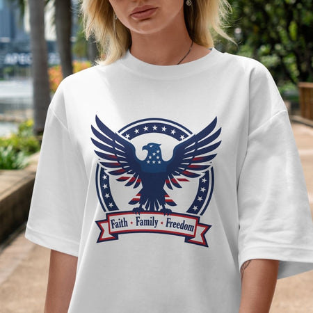 Person wearing a white t-shirt with an eagle graphic and 'Faith Family Freedom' text.