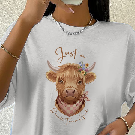 Person wearing a white t-shirt with a cow illustration and text.