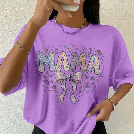 Person wearing a purple t-shirt with 'MAMA' and decorative elements.