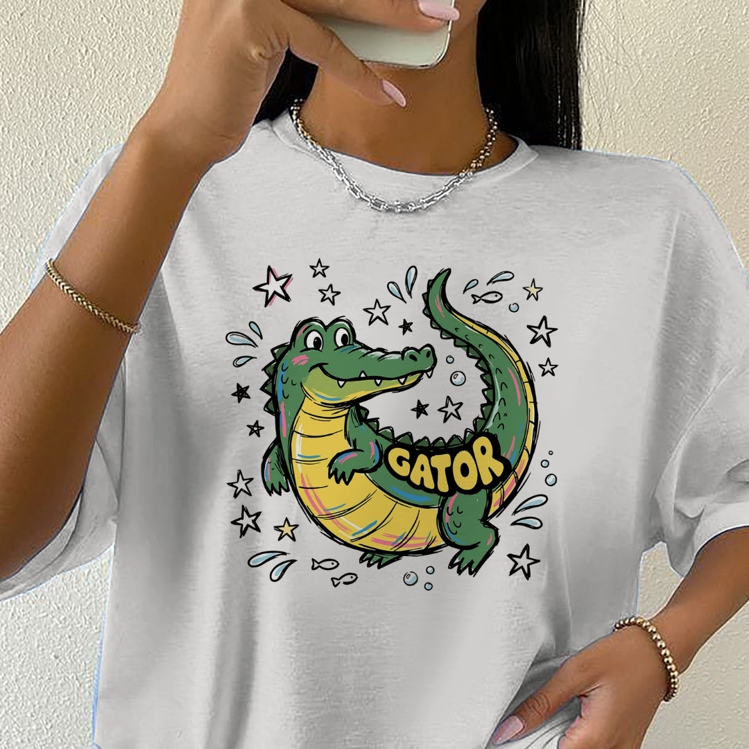 Person wearing a white t-shirt with a cartoon alligator design and 'GATOR' text.