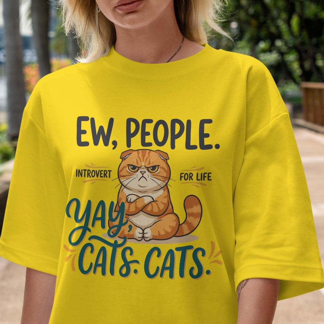 Person wearing a yellow t-shirt with a cat graphic and text.