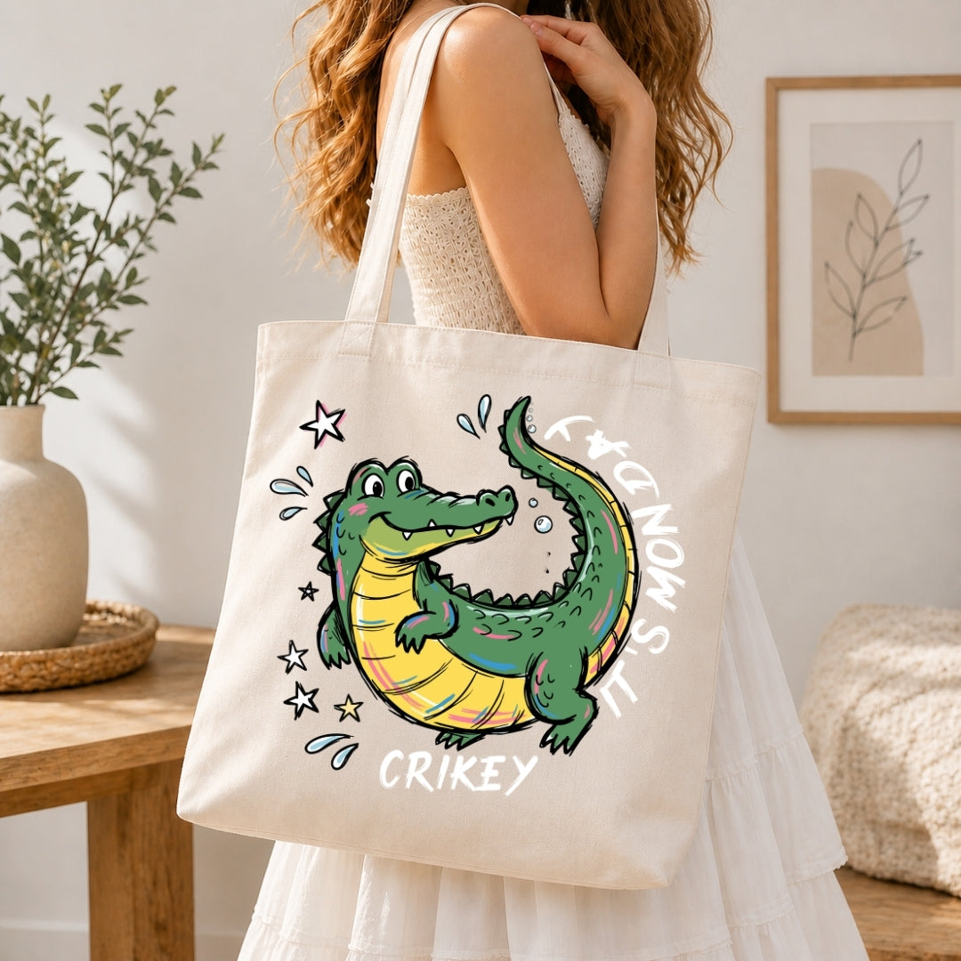 Person holding a tote bag with a cartoon alligator design in a home setting