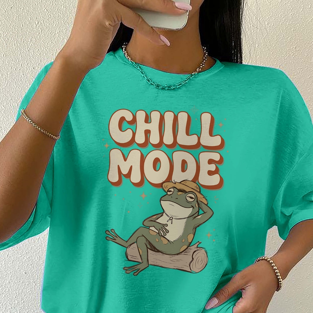 Person wearing a teal t-shirt with a frog graphic and 'Chill Mode' text.
