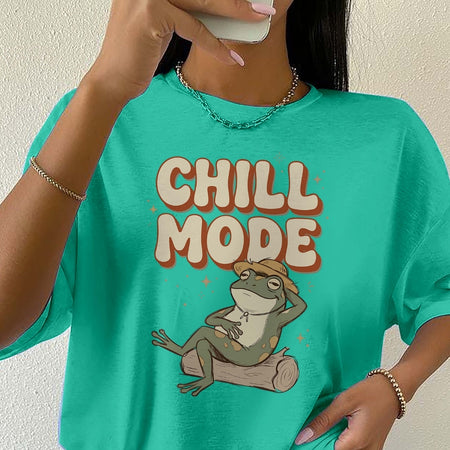 Person wearing a teal t-shirt with a frog graphic and 'Chill Mode' text.