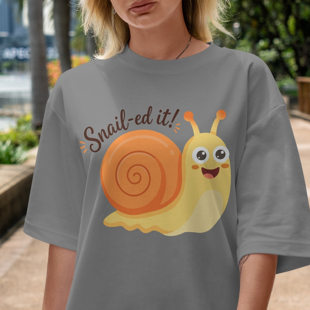 Person wearing a gray t-shirt with a cartoon snail and 'Snail-ed it!' text.