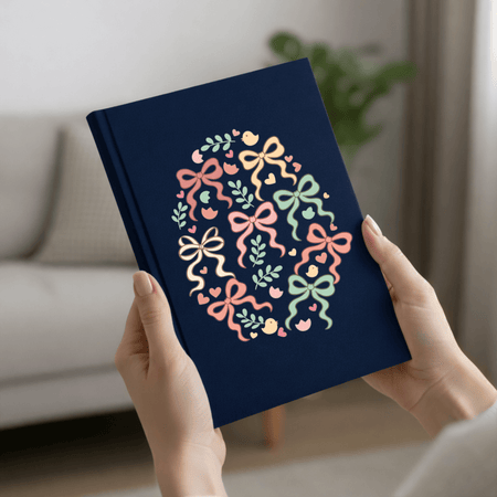 Navy blue notebook with colorful bow design held by hands in a home setting