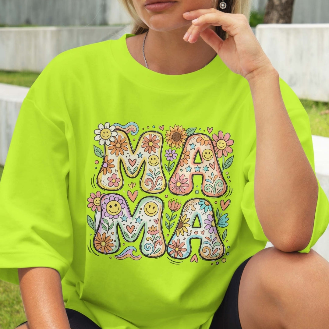 Person wearing a bright green t-shirt with colorful 'MAMA' design.