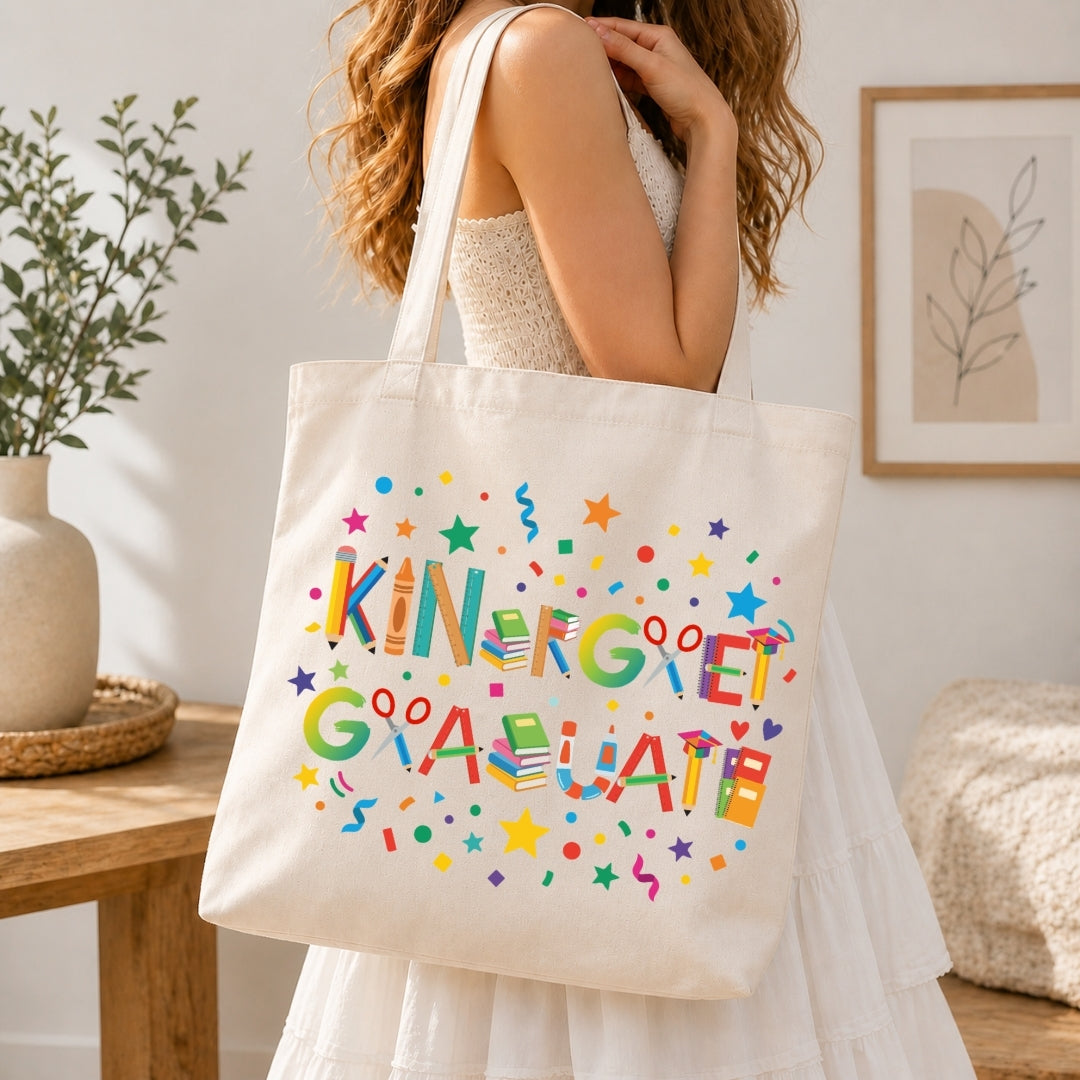 Person holding a tote bag with 'Kindergarten Graduate' text and colorful design.