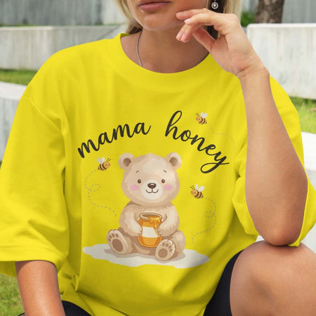 Person wearing a yellow t-shirt with a bear graphic and 'mama honey' text.