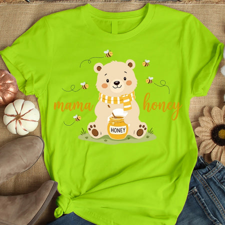 Green t-shirt with a bear graphic and 'mama honey' text on a textured surface.