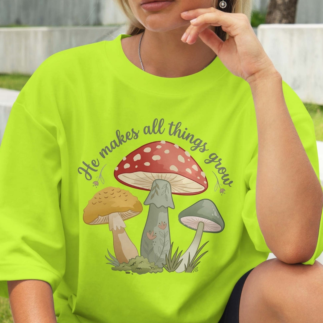 Person wearing a bright green t-shirt with mushroom design and text.