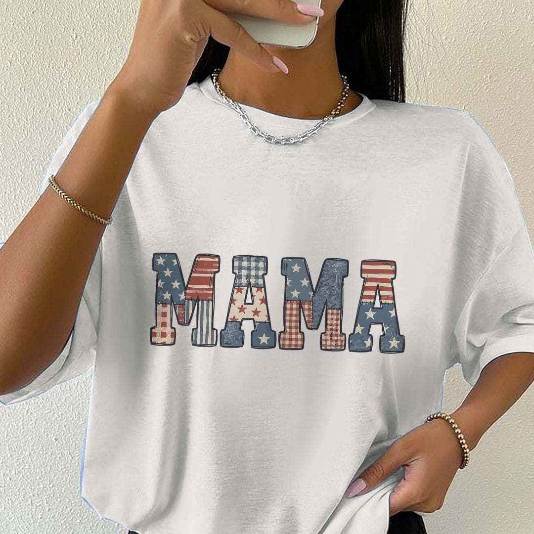 White t-shirt with 'MAMA' text in colorful patterns worn by a person.